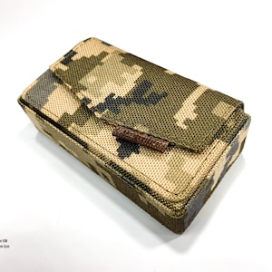 Puede incluir: Una funda de camuflaje para un IEM (In-Ear Monitor) con un tirador de cremallera marrón. La funda mide 10 cm x 5 cm x 3 cm. Hecho en Ucrania.