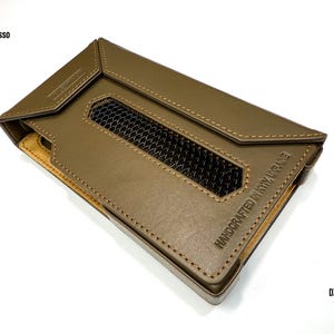 Puede incluir: Funda de cuero verde oliva con una rejilla de ventilaci&oacute;n y bordes cosidos. La funda tiene el texto "HANDCRAFTED IN KYIV, UKRAINE" y "DX 340" impresos. Tambi&eacute;n es visible la marca "iBasso".