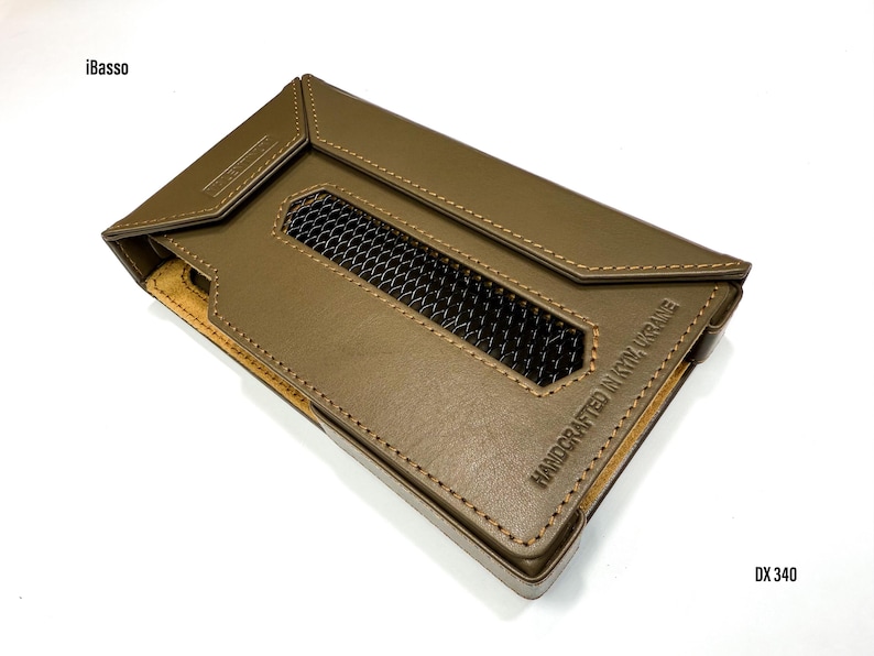 Puede incluir: Funda de cuero verde oliva con una rejilla de ventilaci&oacute;n y bordes cosidos. La funda tiene el texto "HANDCRAFTED IN KYIV, UKRAINE" y "DX 340" impresos. Tambi&eacute;n es visible la marca "iBasso".
