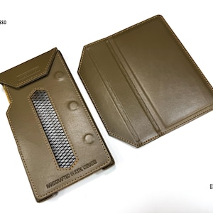 Puede incluir: Funda de cuero verde oliva para reproductor de audio digital, con ventana rectangular y cierres de bot&oacute;n a presi&oacute;n. La funda est&aacute; abierta, revelando el interior. El texto "HANDCRAFTED IN KYIV, UKRAINE" es visible. Los textos "iBasso" y "DX 340" tambi&eacute;n son visibles.