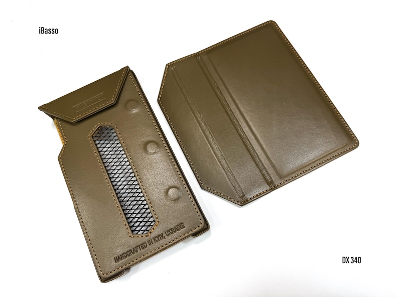 Puede incluir: Funda de cuero verde oliva para reproductor de audio digital, con ventana rectangular y cierres de bot&oacute;n a presi&oacute;n. La funda est&aacute; abierta, revelando el interior. El texto "HANDCRAFTED IN KYIV, UKRAINE" es visible. Los textos "iBasso" y "DX 340" tambi&eacute;n son visibles.