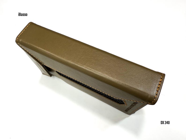 Puede incluir: Funda de cuero verde oliva para un reproductor de audio digital iBasso DX340. La funda es rectangular con un borde cosido y un panel de malla. El texto iBasso y DX 340 es visible en la funda.