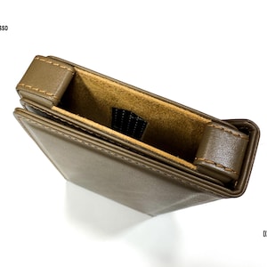 Puede incluir: Una funda de cuero marr&oacute;n con interior beige. La funda rectangular tiene una solapa y est&aacute; cosida con hilo beige. Los textos "iBasso" y "DX 340" son visibles.