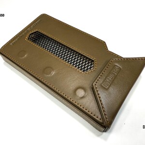 Puede incluir: Una funda de cuero marr&oacute;n con una rejilla rectangular y el texto "VALENTINUM" en relieve en el lateral. La funda tiene un borde cosido y tres hendiduras circulares. El texto "iBasso" es visible en la parte superior izquierda y "DX 340" en la inferior derecha.