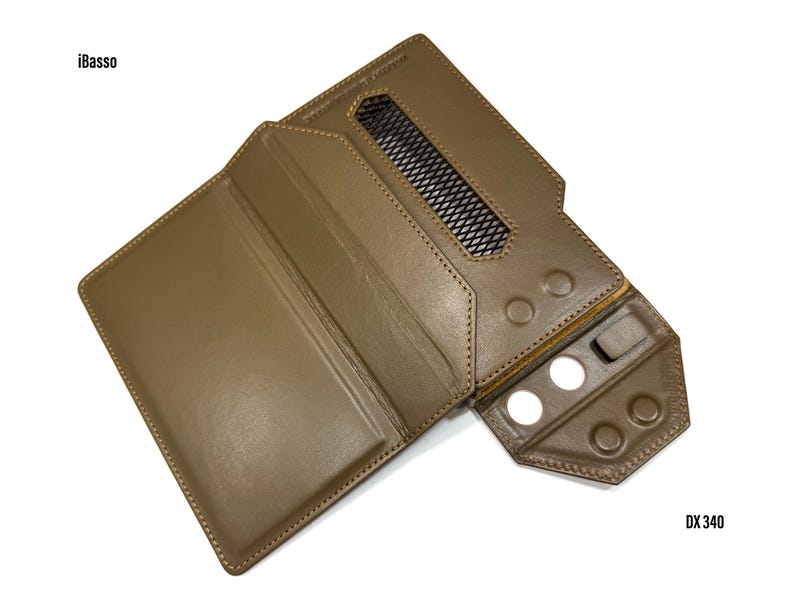 Puede incluir: Una funda de cuero marr&oacute;n para reproductor de audio digital, con el texto "iBasso" y "DX 340". La funda tiene una rejilla de ventilaci&oacute;n y varios recortes circulares para botones. La funda est&aacute; abierta, revelando el interior.