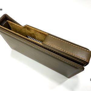 Puede incluir: Una funda de cuero marr&oacute;n con interior beige y costuras en contraste. La funda tiene un recorte para un dispositivo. El texto "iBasso" es visible en la parte superior izquierda y "DX 340" en la inferior derecha.
