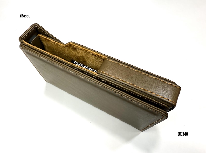 Puede incluir: Una funda de cuero marr&oacute;n con interior beige y costuras en contraste. La funda tiene un recorte para un dispositivo. El texto "iBasso" es visible en la parte superior izquierda y "DX 340" en la inferior derecha.