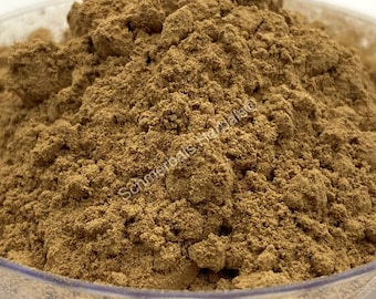 May include: Close-up of a pile of brown powder in a clear plastic container. The powder is finely ground and has a uniform texture. The label on the container reads "Schumerbals Herbals".