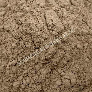 May include: Close-up of a pile of light brown powder. The powder is finely ground and has a uniform texture. The text "SCHIMMERBALSHERBALS®" is visible in the lower right corner of the image.