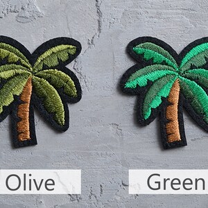 May include: Two embroidered palm tree patches, one in olive green and one in bright green. The patches are on a gray background.