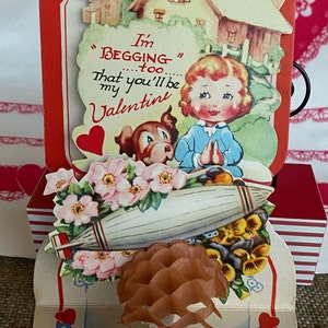 Carte de Saint-Valentin pliée en deux couches, imprimée par lithographie des années 40 avec accent en nid d'abeille, fille et chien, fusée et maison, 6" de haut