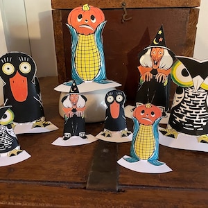 Può includere: Un set di sette sagome di Halloween vintage in carta. Le sagome includono un gufo, un corvo, una strega, una zucca e un gambo di mais. Le sagome sono tutte in nero, bianco e arancione.