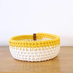 Panière de rangement vue de face, réalisée avec de la corde écrue et jaune.