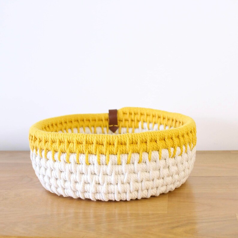 Panière de rangement vue de face, réalisée avec de la corde écrue et jaune.