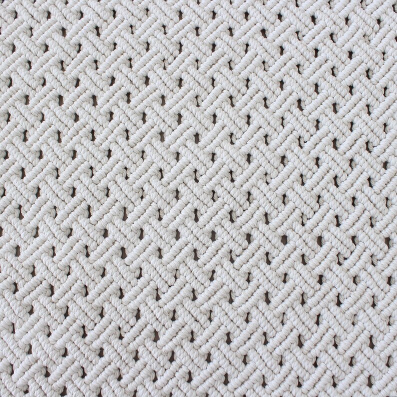 May include: White macrame wall hanging with a diamond pattern.