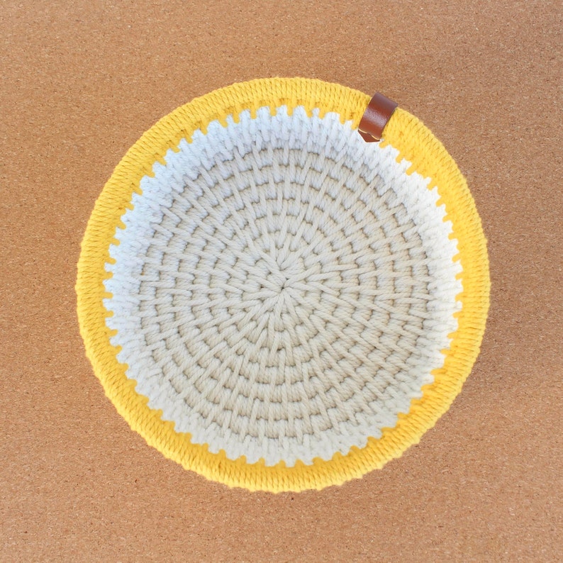 Panière de rangement vue du dessus, réalisée avec de la corde écrue et jaune.