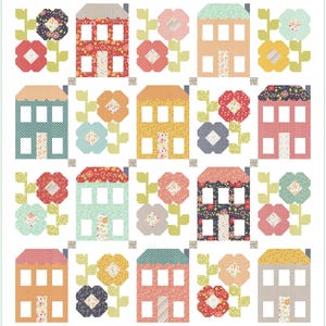 May include: A quilt pattern featuring a repeating design of houses and flowers. The houses are in various colors, including red, yellow, blue, and green. The flowers are in shades of pink, orange, and blue. The background is white.