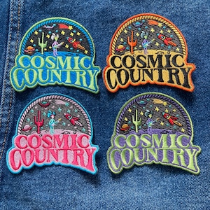May include: Four embroidered patches with a cosmic country theme. Each patch features a cartoon alien playing a guitar in front of a cactus and a starry sky. The text "Cosmic Country" is written in a colorful, retro font.
