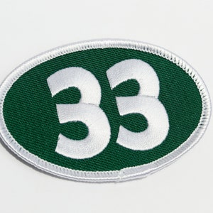 May include: A white oval patch with a green background and the number 33 in white.