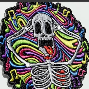 May include: Embroidered patch featuring a skeleton with hands covering its ears, surrounded by colorful musical notes and swirling lines. The skeleton has a wide open mouth and a red tongue. The patch has a black border.