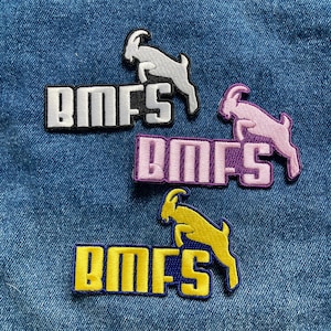 May include: Three embroidered patches with the text "BMFS" in white, purple, and yellow. Each patch features a stylized goat jumping over the text.