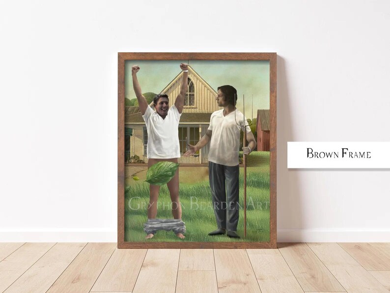 May include: A framed artwork featuring two figures in a rural setting. One figure, wearing a white shirt, raises their arms. The other figure, in a white shirt and blue pants, holds a pitchfork. The artwork is in a brown frame.