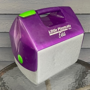 以下が含まれることがあります： 緑色の取っ手付きの紫と銀色のリトルプレイメイトエリートクーラー。