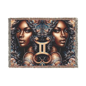 May include: A tapestry throw blanket featuring a detailed illustration of the Gemini zodiac sign with two women's faces on either side. The background is a dark blue with gold and silver accents.