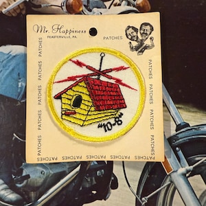 May include: A vintage patch from Mr. Happiness, featuring a yellow and red birdhouse design with a yellow border. The patch has the text "10-8" and is on a cardboard backing with the text "PATCHES".