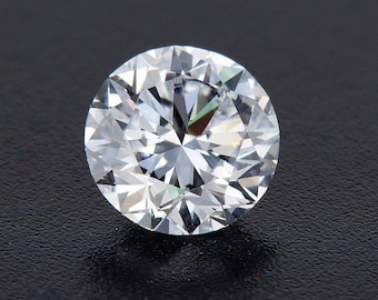 May include: A clear, round diamond gemstone with many facets, reflecting light.