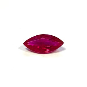 May include: A marquise-shaped ruby gemstone with a deep red color.