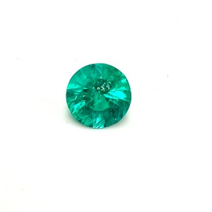 May include: A round, faceted emerald gemstone with a deep green color.