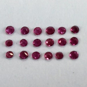 May include: Twenty-four round, pink gemstones arranged in three rows of eight.