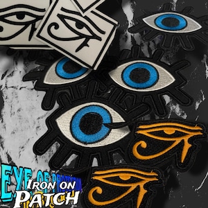 May include: Collection of embroidered patches featuring eye designs. The patches include a blue eye with black detailing, a white eye with black detailing, and an orange eye with black detailing. The text "EYE OF PROTECTION IRON ON PATCH" is also visible.