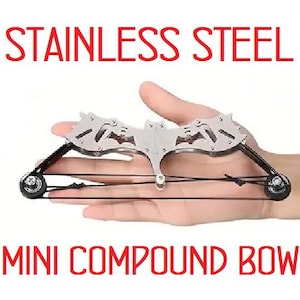 May include: A silver mini compound bow made of stainless steel. The bow is held in a hand and has a black string.