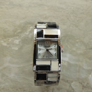 Damen- und Herrenuhr. Schwarzes weißes Armband