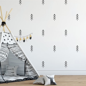 May include: A white teepee tent with black and white geometric patterns and a black and white star pattern. The teepee is decorated with a pillow that says "Dream Big Little One". The teepee is in front of a white wall with black tree silhouettes.
