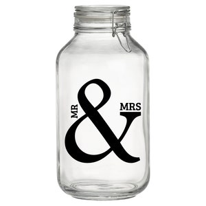Peut inclure: Un pot en verre transparent avec un design d'esperluette noir et blanc et les mots "MR & MRS" sur le devant.