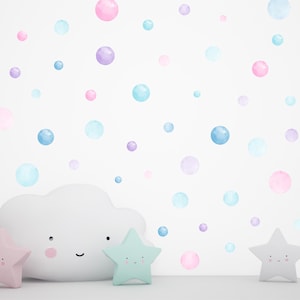 Peut inclure: Un nuage blanc avec un visage souriant, deux étoiles, une rose et une verte, et un mur blanc avec des points d'aquarelle bleu pastel, rose et violet.