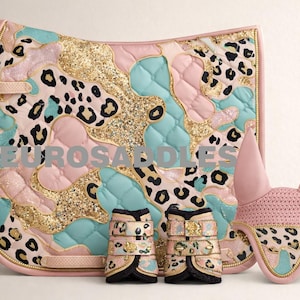 Puede incluir: Un conjunto ecuestre a juego que incluye una manta de silla, una gorra para las orejas y vendas para las piernas. El conjunto tiene una base rosa con un diseño de estampado de leopardo en negro, dorado y turquesa. El texto "EUROSADDLES" es visible en la manta de silla.
