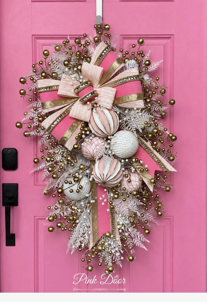 Glam Swag — teardrop swag with pink and white striped ornaments, gold berry sprays, white fern foliage, and a pink and champagne gold bow