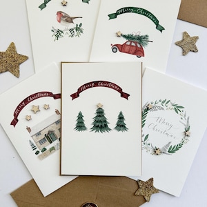 Luxuriöse illustrierte Weihnachtskarten mit Holzsternen - Rotkehlchen, rotes Auto, verschneite Hütte, Bäume, festlicher Kranz mit Kraftpapier-Umschlägen