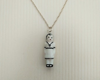 Frozen Charlotte Doll in Sashed Frock Pendant with Silver Chain