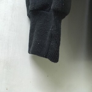 May include: Close-up of a black sweatshirt cuff. The cuff is made of a soft, knitted fabric.