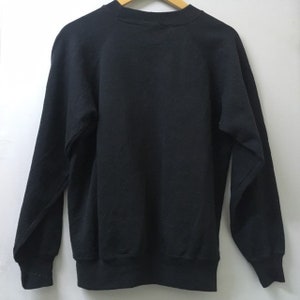 May include: A black sweatshirt with a crew neck and long sleeves. The sweatshirt is made of a soft, comfortable material.