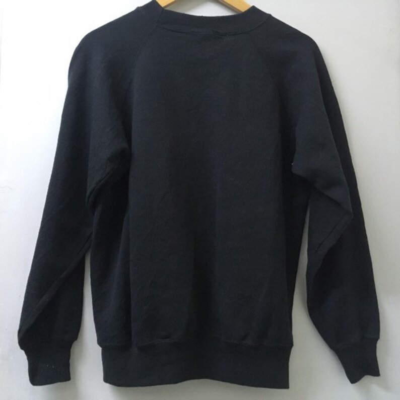 May include: A black sweatshirt with a crew neck and long sleeves. The sweatshirt is made of a soft, comfortable material.