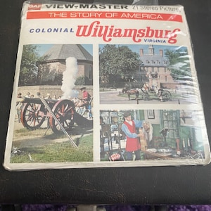 May include: A View-Master reel featuring 21 stereo pictures of Colonial Williamsburg, Virginia. The reel is titled "The Story of America". The front of the reel shows three images: a cannon being fired, a horse-drawn carriage, and a man in period clothing.