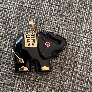 Colgante vintage de oro amarillo de 14k con ojo de rubí y ónix negro natural tallado a mano con forma de elefante.