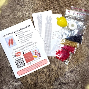 Peut inclure: Un kit de boucles d'oreilles avec le texte "MMIW Red Dress Earring Kit" comprend du fil Nymo, de la cire d'abeille, des perles de rocaille, des perles acryliques et des crochets d'oreilles. Le kit comprend également un lien vers un tutoriel vidéo et un code QR.