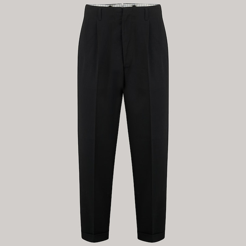 Puede incluir: Pantalones negros con pliegues y dobladillo vuelto. Los pantalones tienen un dise&ntilde;o cl&aacute;sico con cierre de bot&oacute;n y cremallera. Los pantalones est&aacute;n hechos de una tela negra lisa y son adecuados para diversas ocasiones.